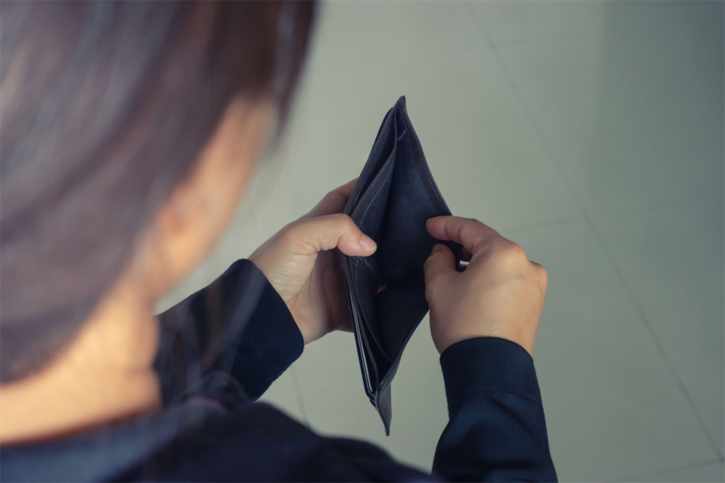 A woman opening an empty wallet