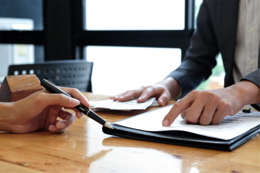 Hands pointing and signing an agreement