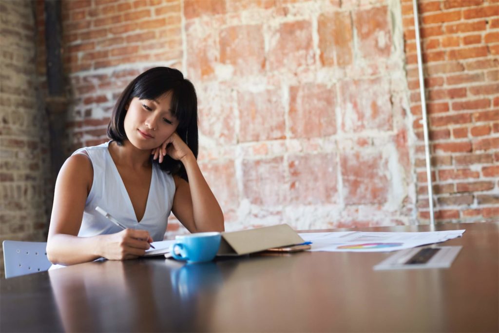 a woman making notes on a notebook