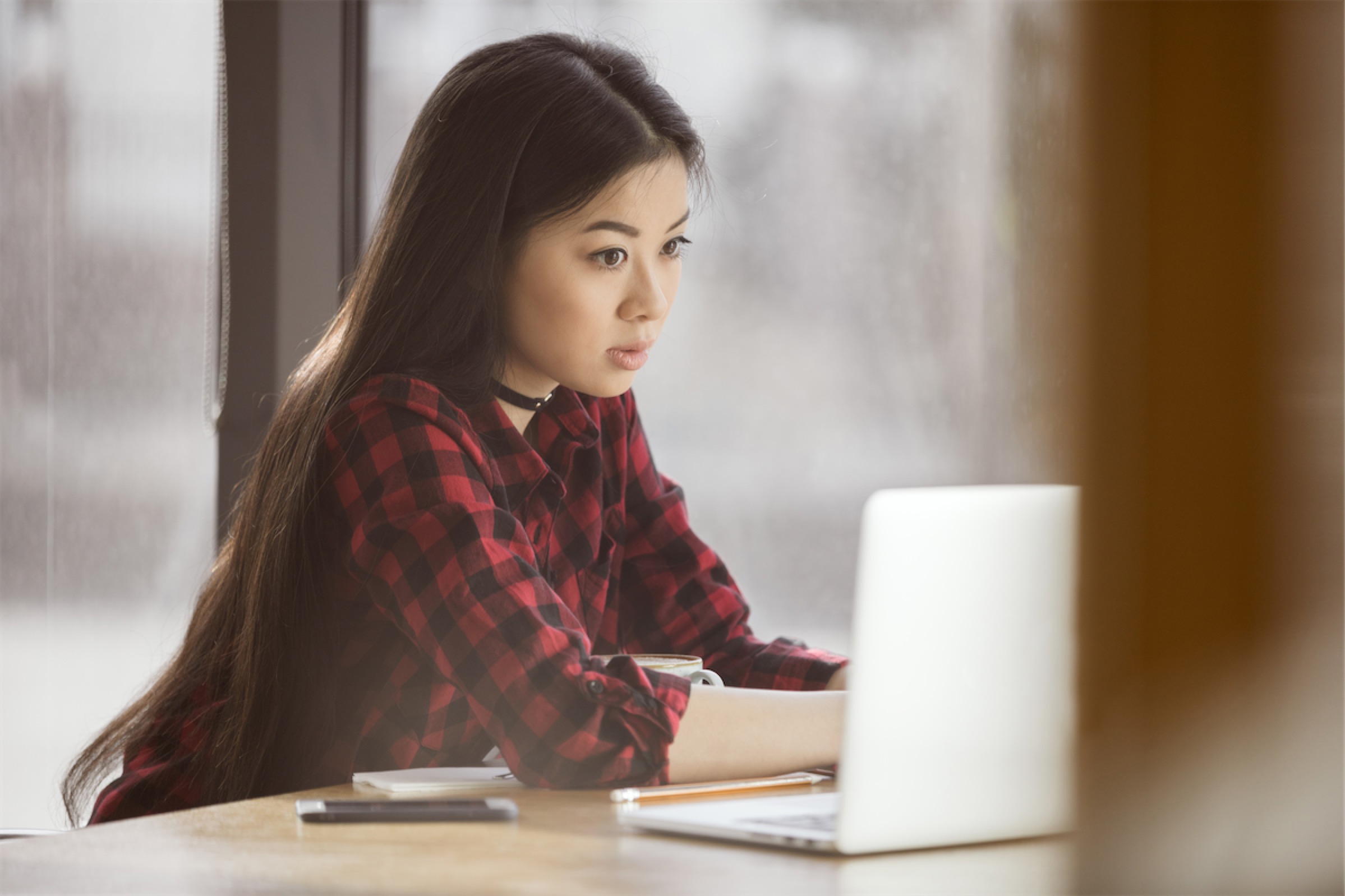 Young lady on a laptop seeking out a personal loan in Singapore