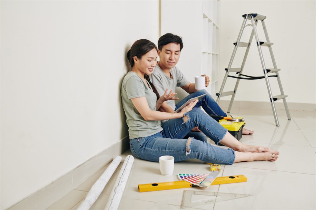 a couple sitting on the floor discussing about renovation