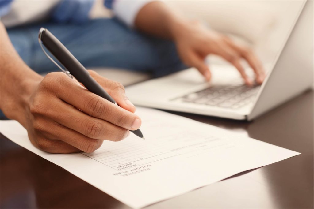 An individual writing down his repayment plan for his personal loan in Singapore