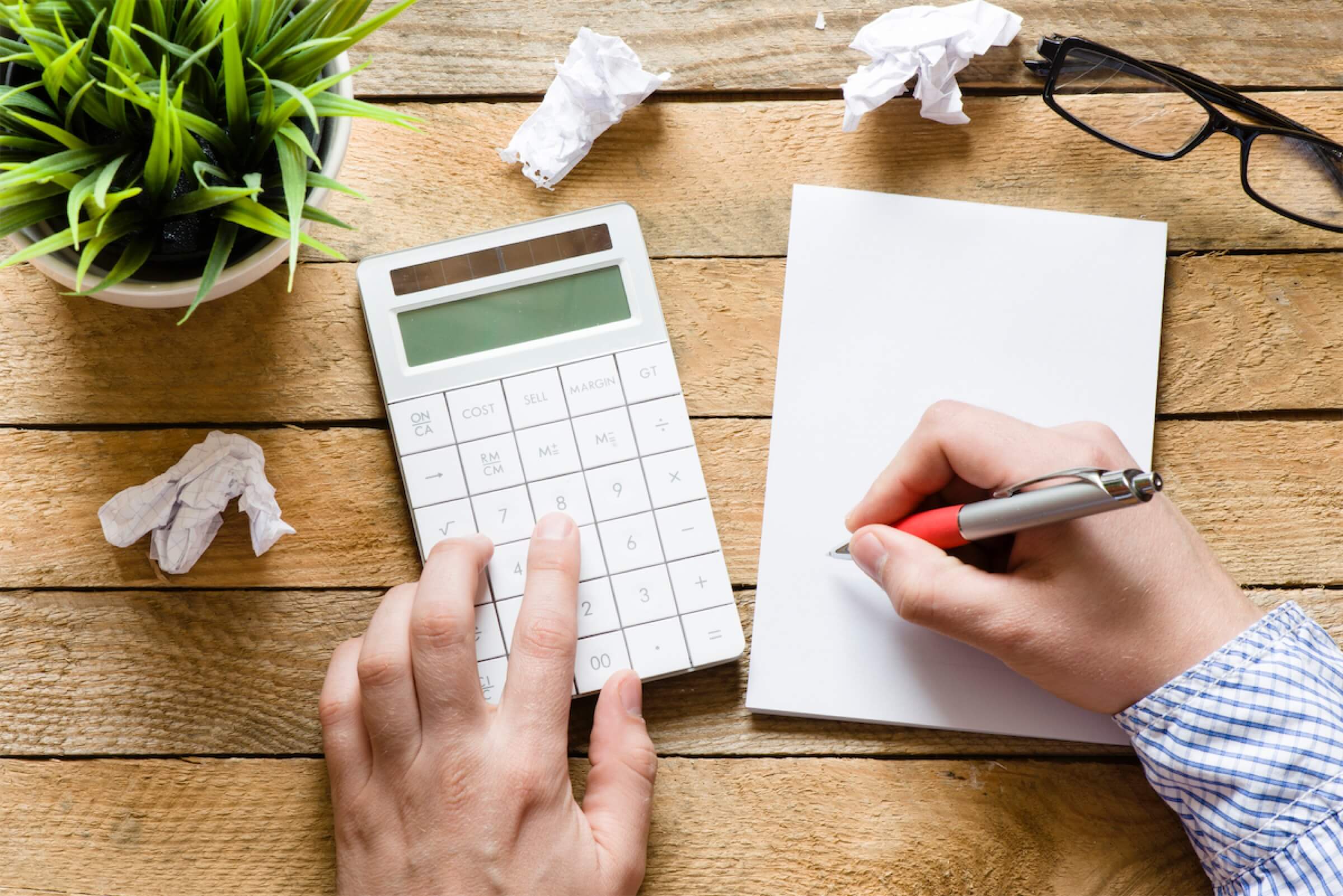 Man writing on a notepad and about to calculate effective interest rate