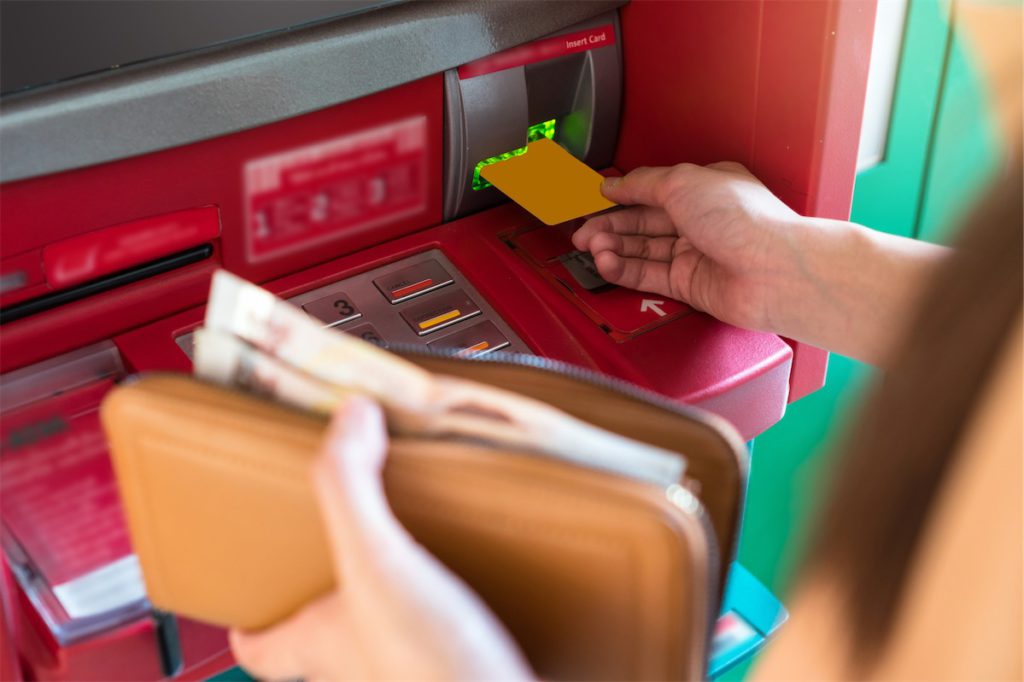 An individual getting an instant cash loan in Singapore and withdrawing it from the ATM