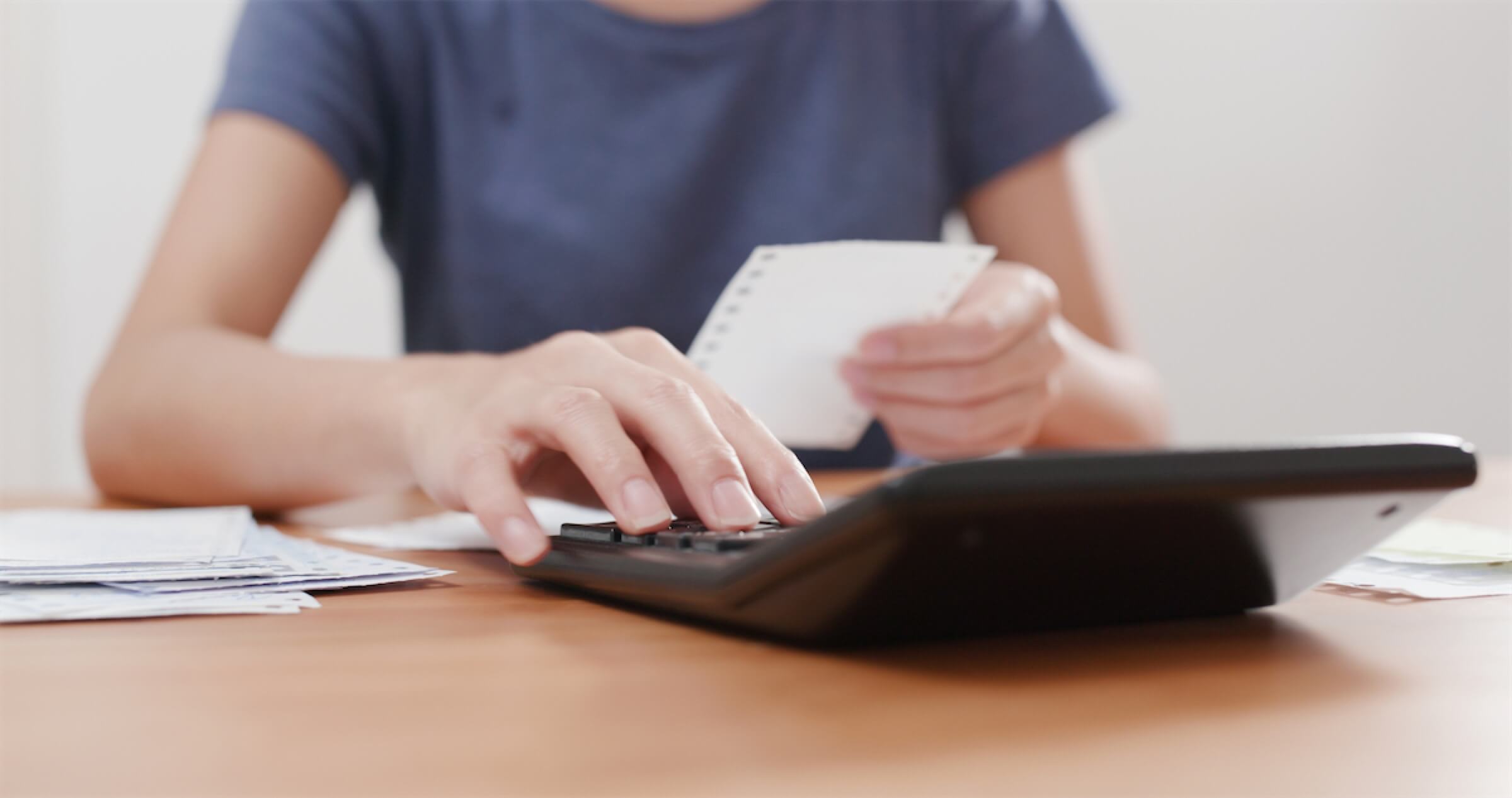 Woman with a calculator working out the cost of a personal loan in Singapore