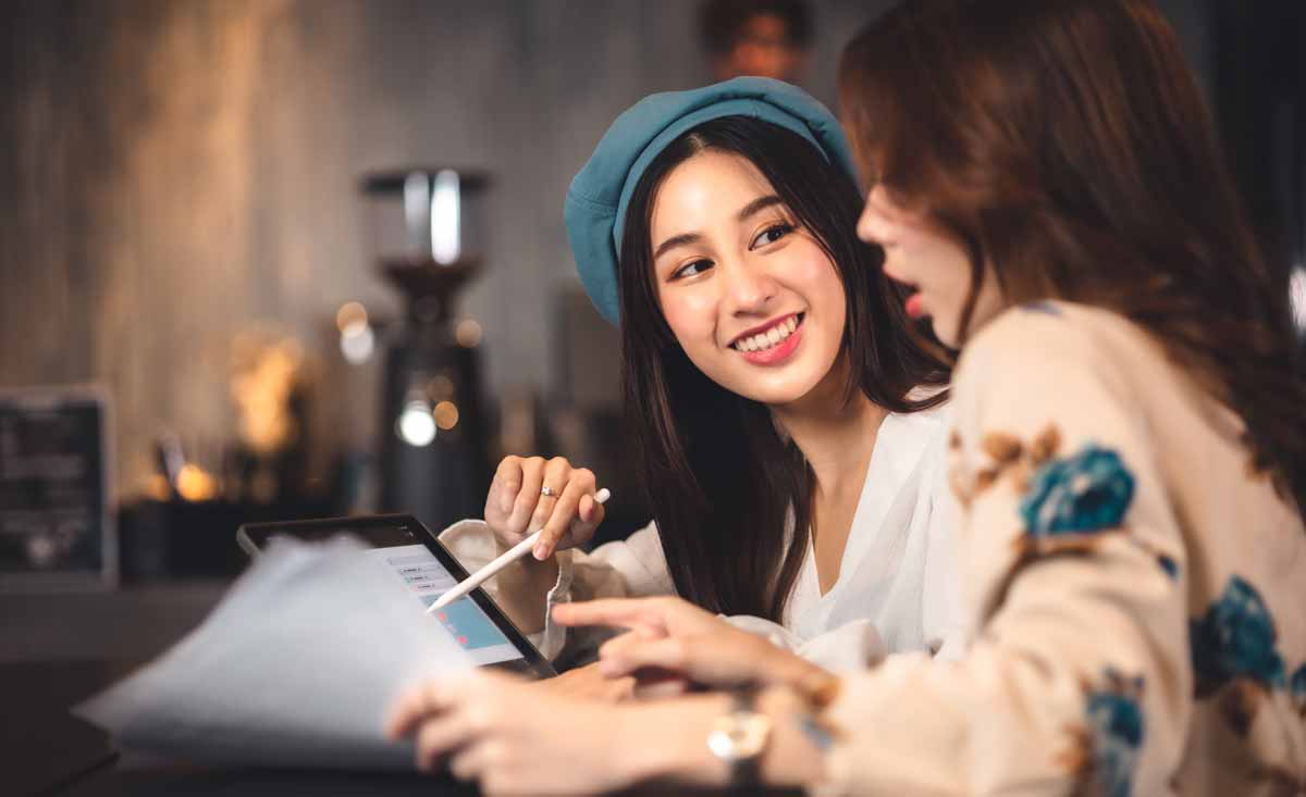 A woman with a calculator and laptop searching for the best personal loan in Singapore